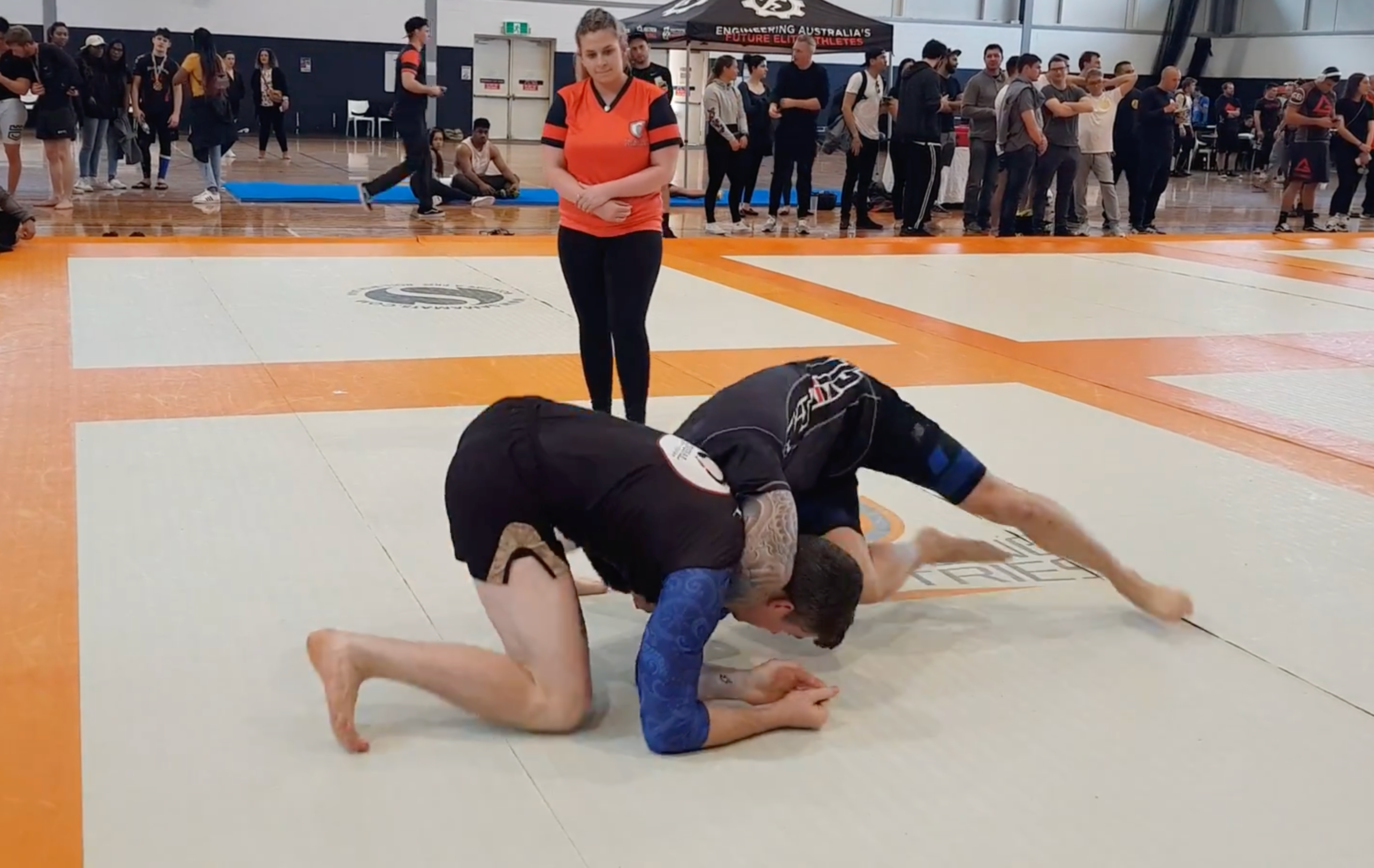 2 men wrestling in a bjj tournament
